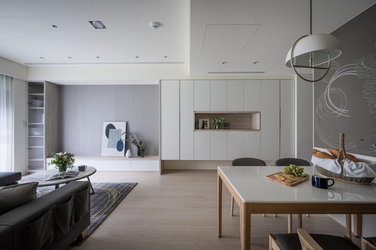 台中北屯住宅客餐廳全景，灰階沙發與木質餐桌搭配自然光